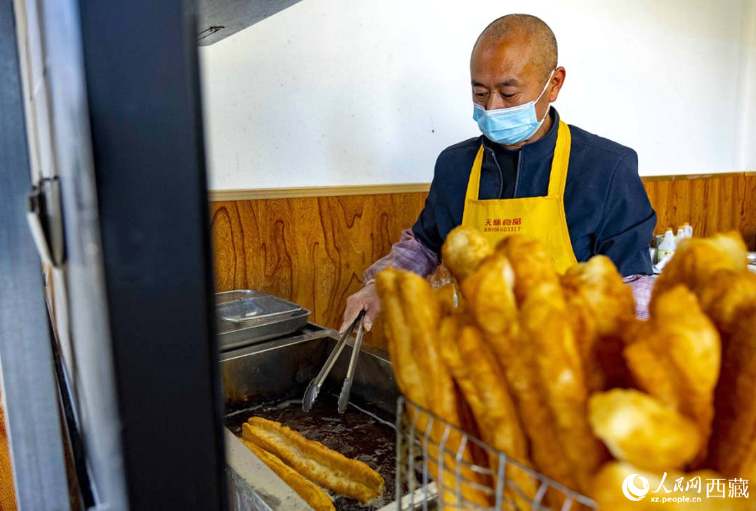 早餐店老板正在炸油條。人民網(wǎng) 次仁羅布攝