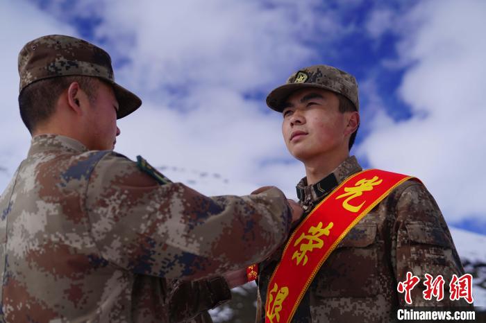 排長(zhǎng)王朝偉(圖左)給退伍老兵佩戴大紅花。　西藏山南軍分區(qū)某團(tuán)供圖