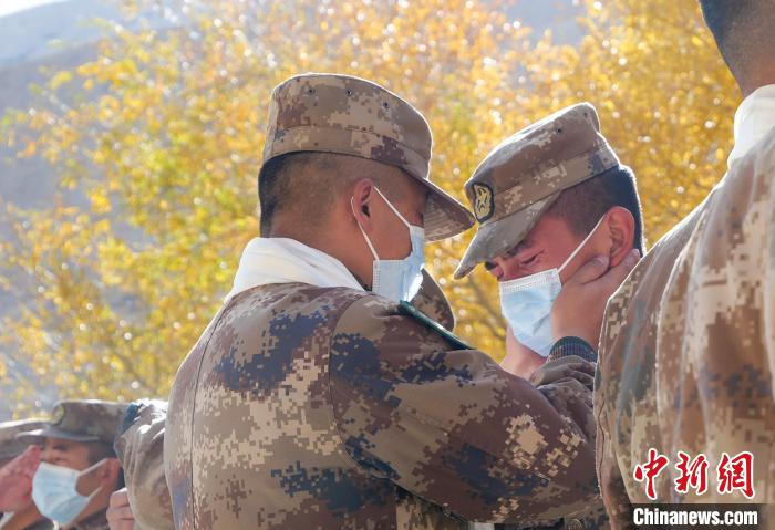 圖為什布奇邊防連退伍老兵與戰(zhàn)友相擁而泣，依依惜別。　徐昌成 攝
