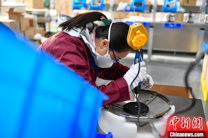圖為工人正在組裝炊具?！∝暩聛硭?攝