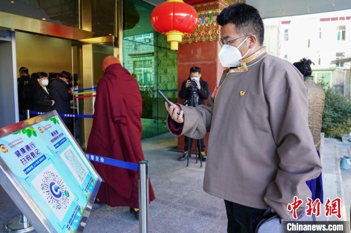 圖為政協(xié)委員掃場所碼進(jìn)入會(huì)場?！〗w波 攝
