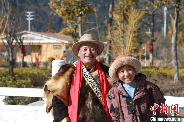 圖為林芝市巴宜區(qū)布久鄉(xiāng)仲果村村民桑杰與孫子一起參加藏歷新年活動(dòng)?！埩?攝