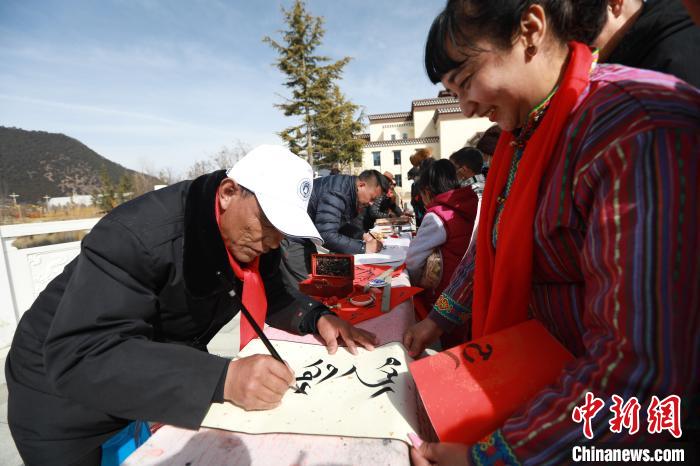 圖為林芝市文聯(lián)書(shū)法家協(xié)會(huì)會(huì)員向民眾贈(zèng)送藏文書(shū)法作品?！埩?攝