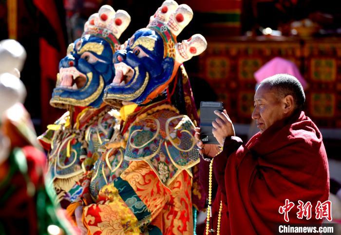 2月19日，正在拍攝跳神活動(dòng)的僧人?！±盍?攝
