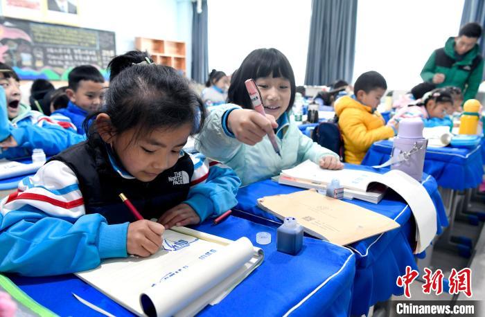 3月14日，西藏拉薩市第一小學(xué)一年級六班學(xué)生白瑪朗珍(圖左)在藏語文課上書寫藏文?！±盍?攝