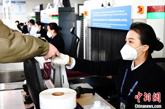 圖為機場工作人員為旅客辦理行李托運?！≈芎?攝