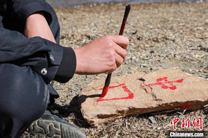 班公湖邊境派出所民警寫(xiě)下“中國(guó)”標(biāo)記。　龍小鳳 攝