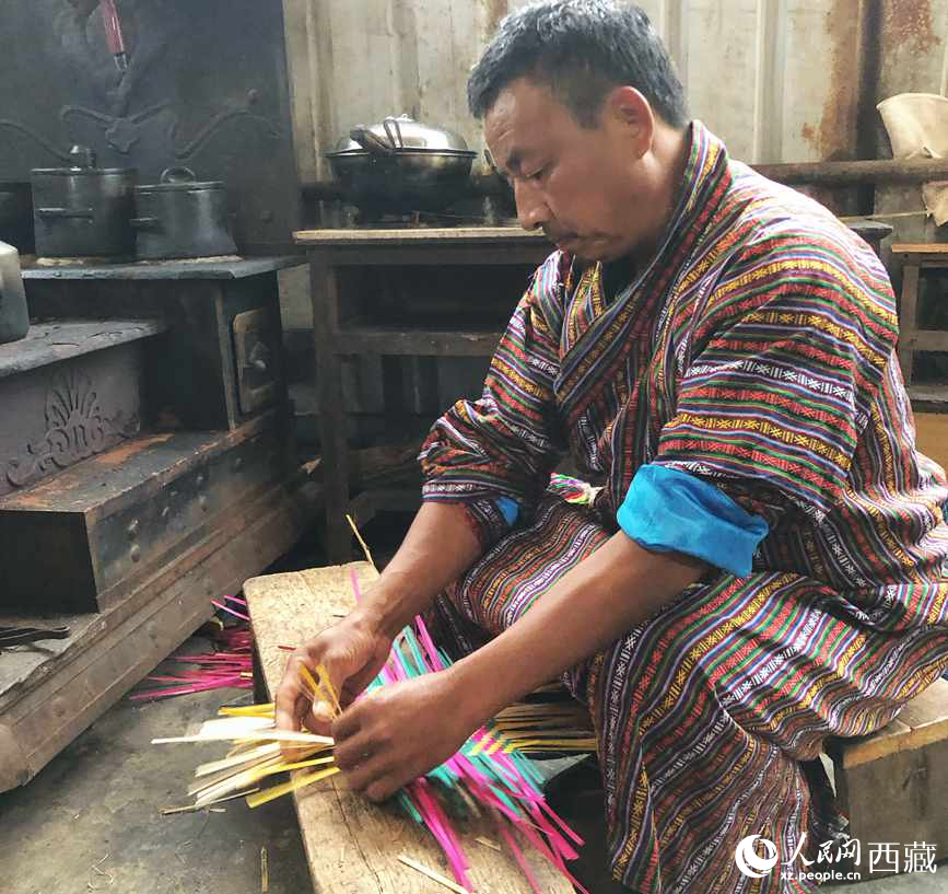 門巴族漢子愛明正在編織藤竹品。